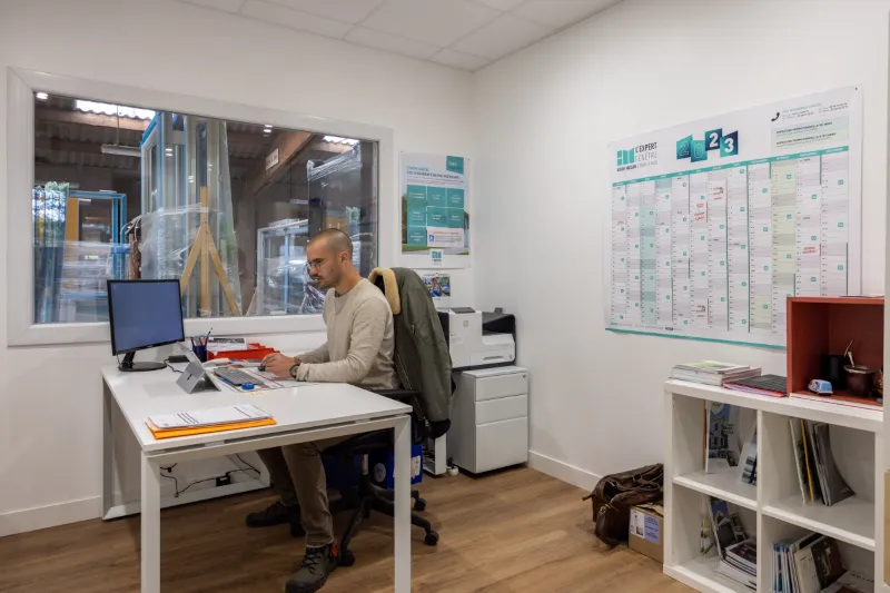 Photo de Camille Bournigal à son poste de travail devant un ordinateur