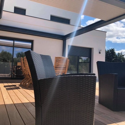 Vue d'une pergola à lames rétractables sur une terrasse exposée au soleil située près de Nantes