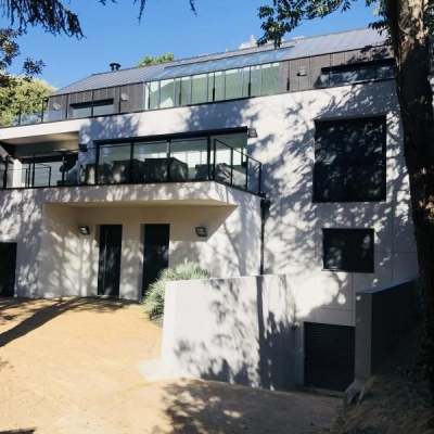 La maison vue de l'extérieur avec ses baies vitrées et ses terrasses 